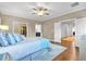 Large bedroom with hardwood floors, decorative pillows, ceiling fan, and multiple doorways at 1099 Heyward Way, Alpharetta, GA 30009