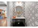 Chic powder room featuring patterned wallpaper, black vanity, a gold mirror, and modern fixtures at 1099 Heyward Way, Alpharetta, GA 30009