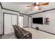 Carpeted bedroom featuring a ceiling fan, a mounted television, a leather recliner, and multiple closets at 1770 Rockland Se Dr, Atlanta, GA 30316