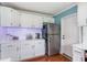 Galley kitchen featuring white cabinetry, stainless steel refrigerator, and wood floors at 1770 Rockland Se Dr, Atlanta, GA 30316