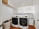 Well-lit laundry room with wooden floors, washer, dryer and storage shelf at 1770 Rockland Se Dr, Atlanta, GA 30316
