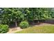 A beautiful backyard with stone firepit, mature trees and a partial fence at 2123 Condor Dr, Lawrenceville, GA 30044