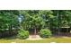 Beautiful backyard featuring a fire pit with mature trees, landscaping and partial fence at 2123 Condor Dr, Lawrenceville, GA 30044