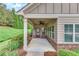 Close up of covered porch and entryway showing brick accents, fan, and manicured lawn at 2384 Tree Arbor Way, Marietta, GA 30064