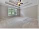 Spacious main bedroom with a tray ceiling, ceiling fan, and a large window providing natural light at 2384 Tree Arbor Way, Marietta, GA 30064