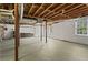Unfinished basement with painted concrete walls, exposed wood ceiling beams, and natural light from two windows at 840 Hickory Sw Dr, Marietta, GA 30064