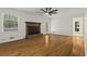 Open living room featuring hardwood floors, a cozy brick fireplace, and a ceiling fan at 840 Hickory Sw Dr, Marietta, GA 30064