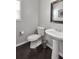Bathroom features white toilet and sink with dark wood flooring and a window for natural light at 2555 Blackstock Dr, Cumming, GA 30041