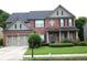 Charming two-story brick home with a well-manicured lawn and a covered front porch at 2555 Blackstock Dr, Cumming, GA 30041