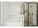 Modern bathroom featuring a separate glass-enclosed shower and soaking tub, with neutral tile and black hardware at 3325 Castleberry Village Cir, Cumming, GA 30040