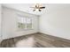 Bedroom with wood-look flooring, ceiling fan, and a large window allowing for natural light at 3325 Castleberry Village Cir, Cumming, GA 30040