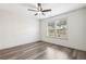 Bright bedroom with wood-look flooring, ceiling fan, and a window overlooking a landscaped yard at 3325 Castleberry Village Cir, Cumming, GA 30040