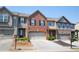 Exterior of townhomes with attached garages, manicured landscaping, and brick and siding exteriors at 3325 Castleberry Village Cir, Cumming, GA 30040