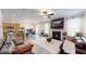 Open-concept living room with fireplace, wood floors, modern lighting, and a view of the adjacent kitchen at 3325 Castleberry Village Cir, Cumming, GA 30040