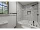 Spa-like bathroom featuring a soaking tub with tile surround, modern fixtures, and a window at 6322 Phillips Creek Dr, Lithonia, GA 30058