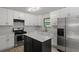 Beautifully updated kitchen with white cabinets, island with marble top, and stainless steel appliances at 6322 Phillips Creek Dr, Lithonia, GA 30058