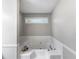 Bathroom featuring a white soaking tub, neutral paint, and a small window at 30 Court S, Ellenwood, GA 30294