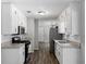 Galley kitchen featuring white cabinets, granite countertops, and stainless steel appliances at 30 Court S, Ellenwood, GA 30294