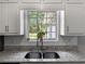 Kitchen sink with stainless steel faucet and view of the landscaped backyard at 30 Court S, Ellenwood, GA 30294