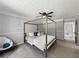 Bright main bedroom showcasing a four-post bed, chair, and carpeted floors at 30 Court S, Ellenwood, GA 30294