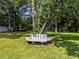 Backyard showing a unique white bench around a tree on a lush green lawn at 30 Court S, Ellenwood, GA 30294