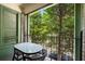View from the balcony, featuring a small table and chairs with a view of lush green trees at 124 Lafayette Ne Dr # 4, Atlanta, GA 30309