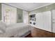 Bedroom featuring hardwood floors, closet/laundry area, shuttered windows and an exterior door at 124 Lafayette Ne Dr # 4, Atlanta, GA 30309