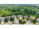 Aerial view of a residential neighborhood, showcasing lush green trees, well-maintained homes, and winding streets at 1650 Walking Horse Trl, Cumming, GA 30041