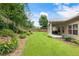 Beautiful backyard with a well-kept lawn, colorful flowers, and a cozy covered patio, ideal for relaxing and entertaining at 1650 Walking Horse Trl, Cumming, GA 30041