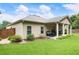 Well-maintained backyard featuring a covered patio, lush lawn, and mature landscaping, perfect for outdoor enjoyment at 1650 Walking Horse Trl, Cumming, GA 30041
