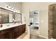 Bathroom featuring a double sink vanity, dark cabinets, tile flooring, and shower with view into the bedroom at 1650 Walking Horse Trl, Cumming, GA 30041