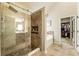 Bathroom featuring a soaking tub, glass shower with tile surround, and view into the closet at 1650 Walking Horse Trl, Cumming, GA 30041