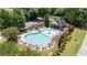 Aerial view of a sparkling community pool surrounded by lounge chairs, lush landscaping, and a shaded pergola at 1650 Walking Horse Trl, Cumming, GA 30041