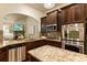 This kitchen features granite counters, stainless appliances, a center island, and stylish brown cabinets at 1650 Walking Horse Trl, Cumming, GA 30041