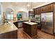 Modern kitchen featuring stainless steel appliances, granite countertops, and wooden cabinetry at 1650 Walking Horse Trl, Cumming, GA 30041