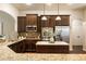 Well-lit kitchen features granite counters, stainless appliances, a center island, and brown cabinetry at 1650 Walking Horse Trl, Cumming, GA 30041