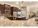 Granite countertops accent stainless appliances, a center island, and beautiful brown cabinetry in this kitchen at 1650 Walking Horse Trl, Cumming, GA 30041