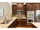 Granite countertops complement the stainless appliances and brown cabinets in this stylish kitchen at 1650 Walking Horse Trl, Cumming, GA 30041