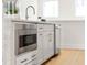 Modern kitchen island with a built-in stainless microwave and light wood floors at 230 New St # 2201-4, Decatur, GA 30030