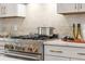 Professional style gas cooktop with pot filler and stainless pot on marble countertops at 230 New St # 2201-4, Decatur, GA 30030