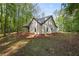 Home exterior featuring a gray roof, beige siding, and an unfinished yard surrounded by trees at 48 Paschal St, Temple, GA 30179
