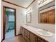 Bathroom with double vanity, wood-trimmed mirrors, and an adjacent toilet and shower area at 4812 Shallow Creek Nw Dr, Kennesaw, GA 30144
