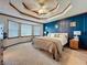 Spacious bedroom featuring a bay window, decorative tray ceiling, and dark blue accent wall at 4812 Shallow Creek Nw Dr, Kennesaw, GA 30144