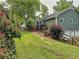 Green home exterior with a well-maintained lawn and vibrant rose bushes in a serene setting at 4812 Shallow Creek Nw Dr, Kennesaw, GA 30144