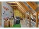 Unfinished attic with plywood sheeting, exposed beams, and storage items at 6445 Lucent Ln, Atlanta, GA 30328