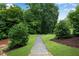 A serene backyard featuring lush greenery and a winding stone path inviting exploration at 6445 Lucent Ln, Atlanta, GA 30328