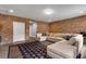 Bright living room with exposed brick wall, large sectional, and decorative rug at 6445 Lucent Ln, Atlanta, GA 30328