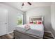This is a bedroom featuring a bed with gray wood laminate flooring and a ceiling fan at 1295 Aster Ives Dr, Lawrenceville, GA 30045
