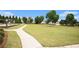 A common area provides a large grassy field with a walking path and a playground in the distance at 1295 Aster Ives Dr, Lawrenceville, GA 30045