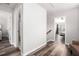 A hallway featuring gray wood laminate flooring leads to a bedroom with a window and an adjacent bathroom at 1295 Aster Ives Dr, Lawrenceville, GA 30045